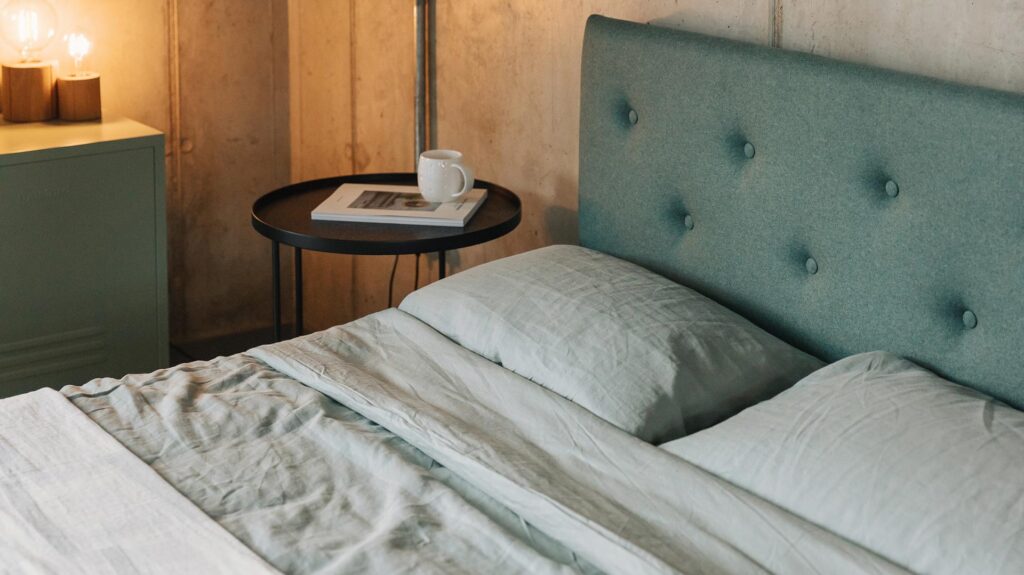 Arran upholstered bed with green upholstered and organic linen bedding