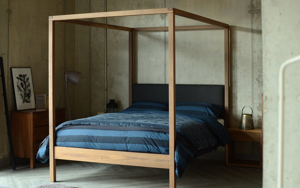 Industrial look bedroom featuring the Highland 4 poster bed in walnut with grey wool padded headboard