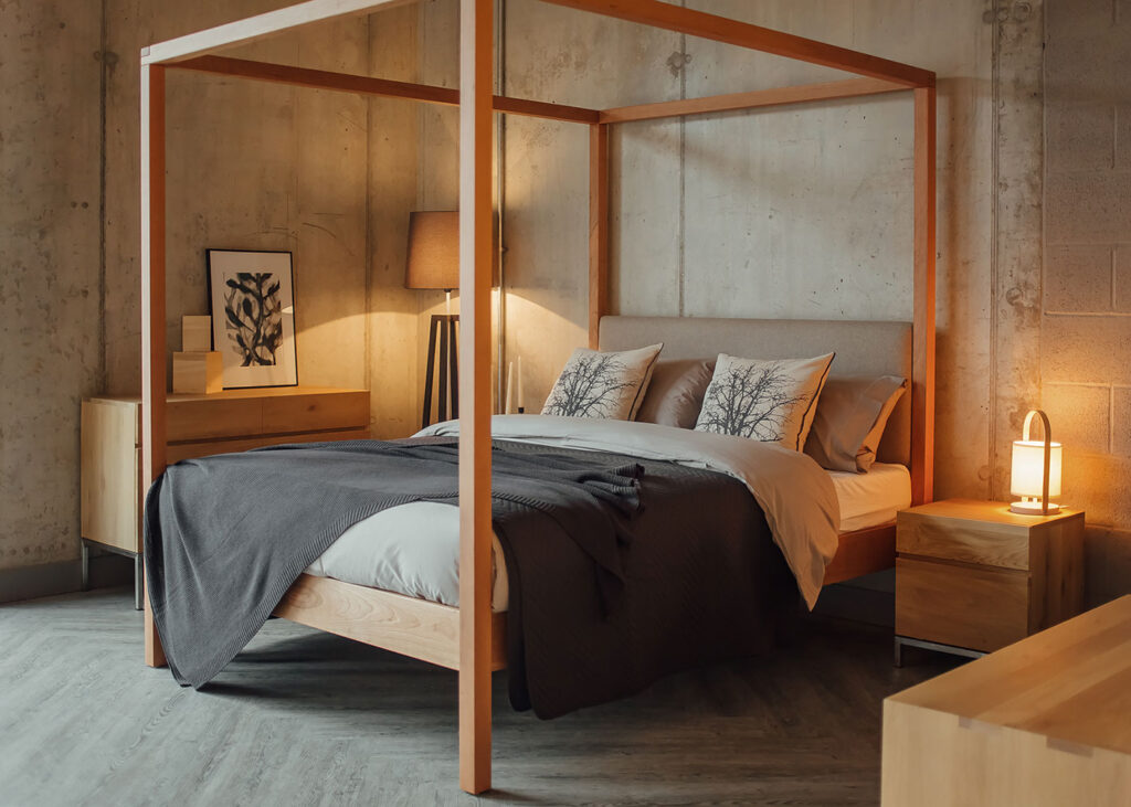 Cosy concrete bedroom featuring our hand-made Highland solid wood upholstered 4 Poster bed in cherry