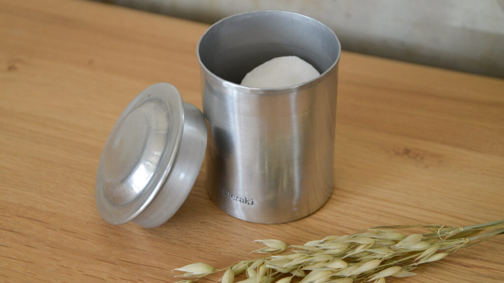 silver meraki storage jar photographed with lid off - leaning against the side of the jar.