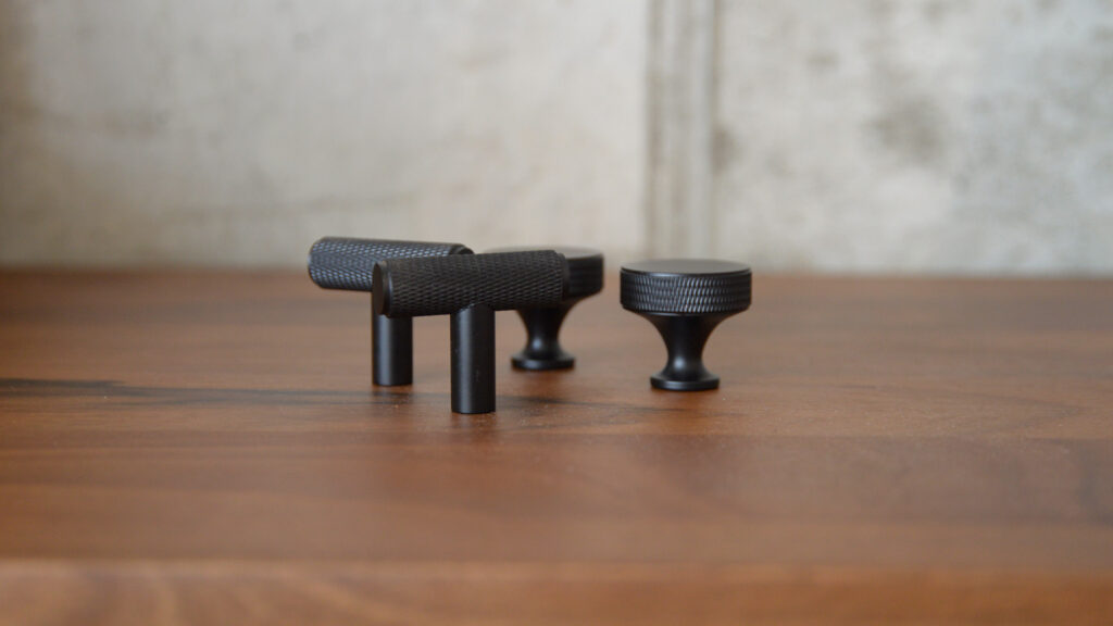 2 round black hooks and 2 t bar black hooks on table.