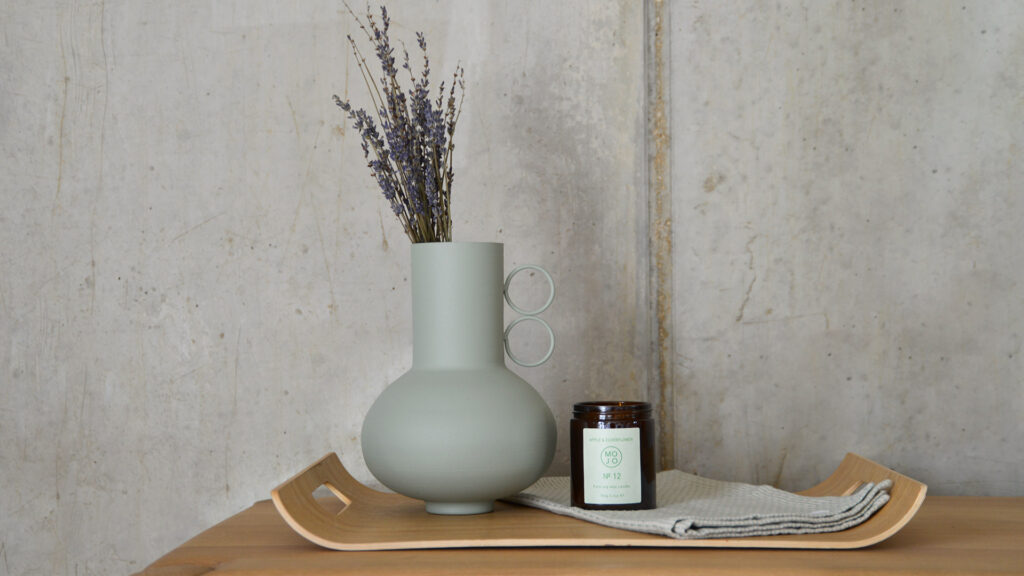 sage vase with lavender on a tray with a candle.