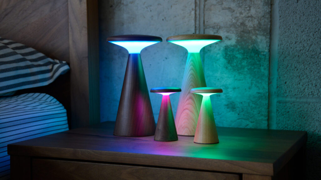 4 retro wooden table lamps. all lit in coloured shades.