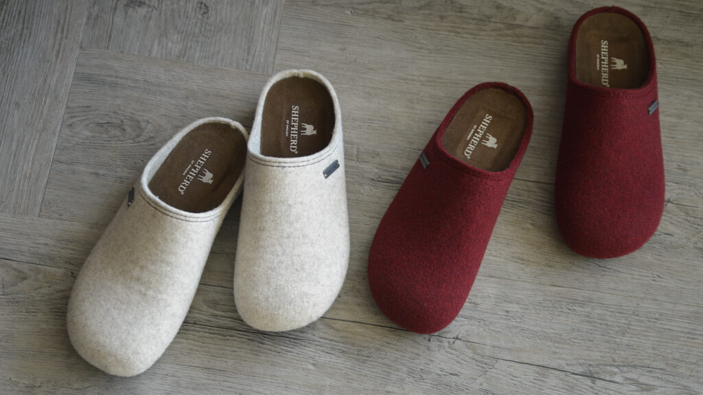 2 pairs of slippers with shepherd logo visible inside. One pair stone, other red.