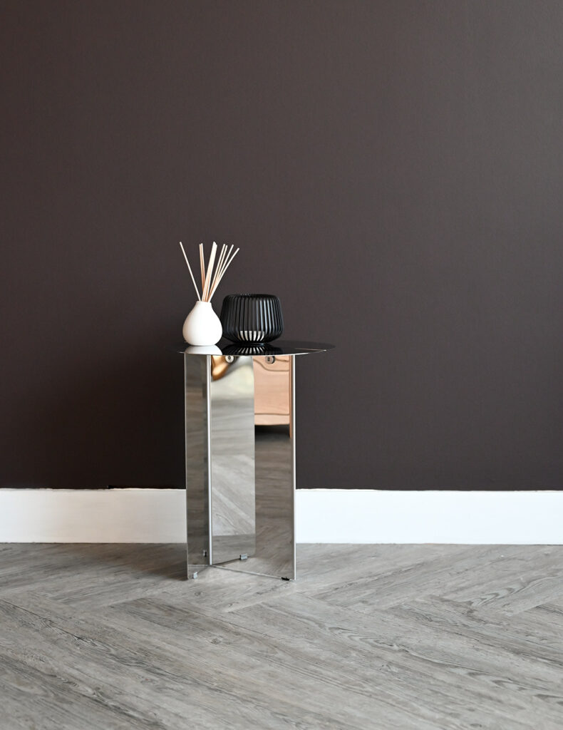 Fully stainless steel side table with diffuser and candle holder on top.