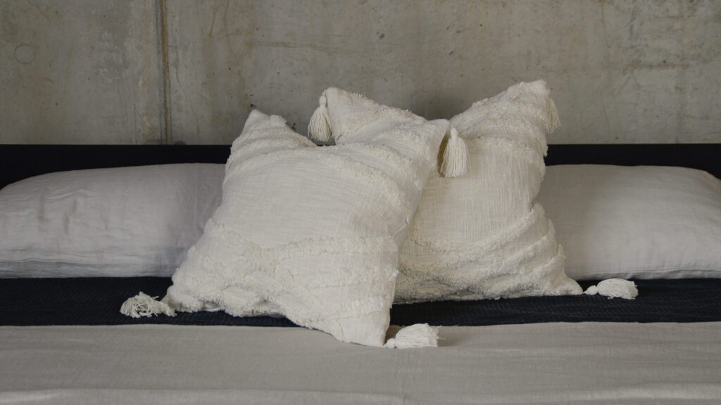 Tasseled Tufted Ecru Cushions with monochrome bedding
