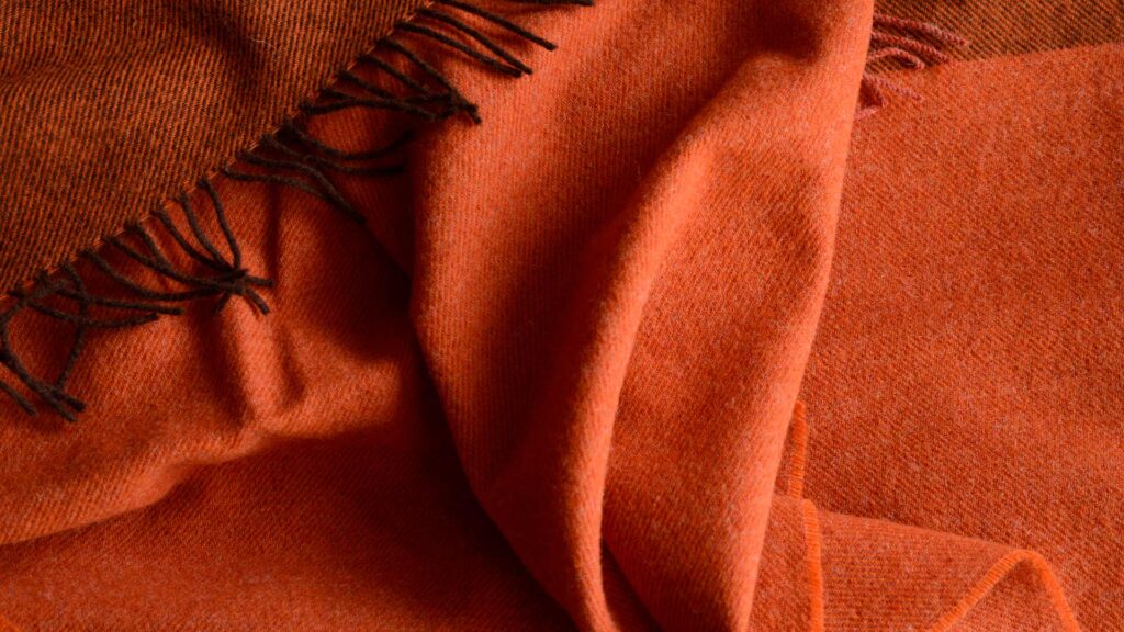100% pure wool colour block throw in orange with brown undertones