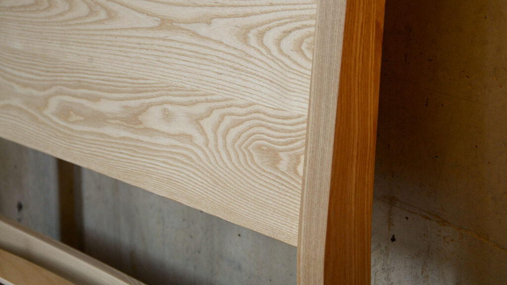 a close up view of the sloping headboard of our classic Zanskar bed hand crafted in solid Ash wood