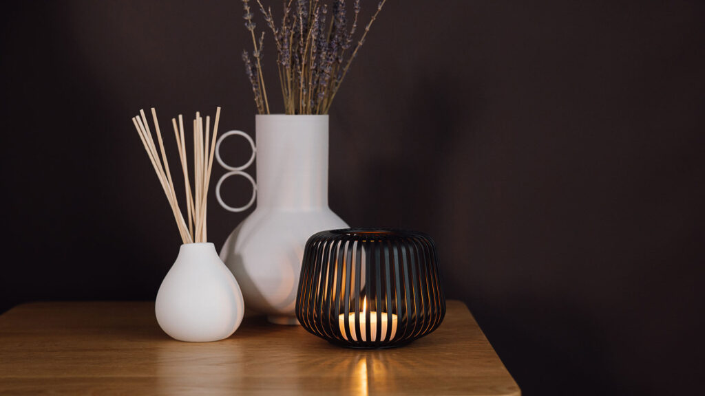 white vase and diffuser with black candle holder.