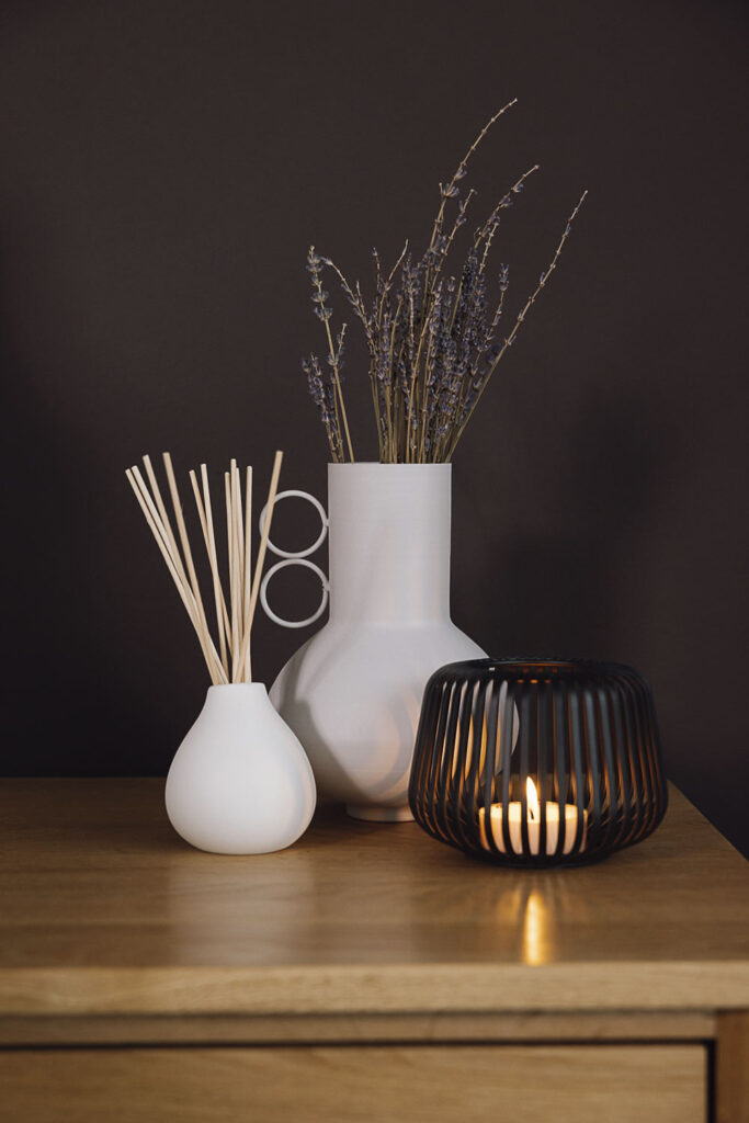 white vase and diffuser with black candle holder.