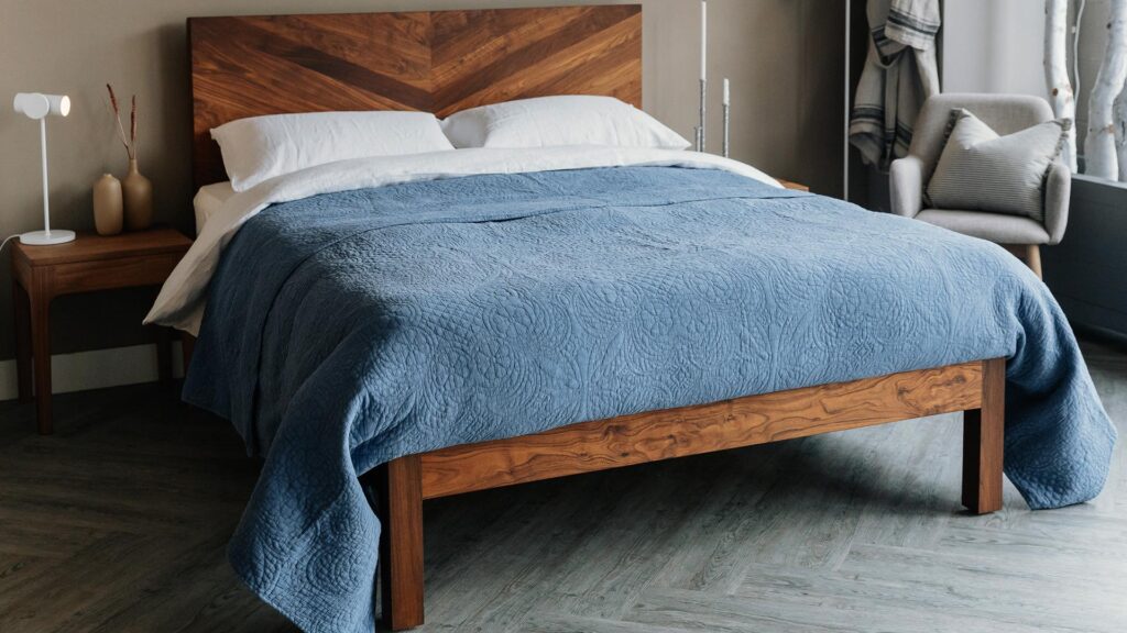 blue bedspread on walnut bed