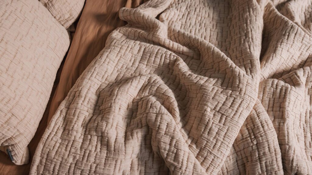 textured bedspread and pillowcase set in Blush pink shown close up