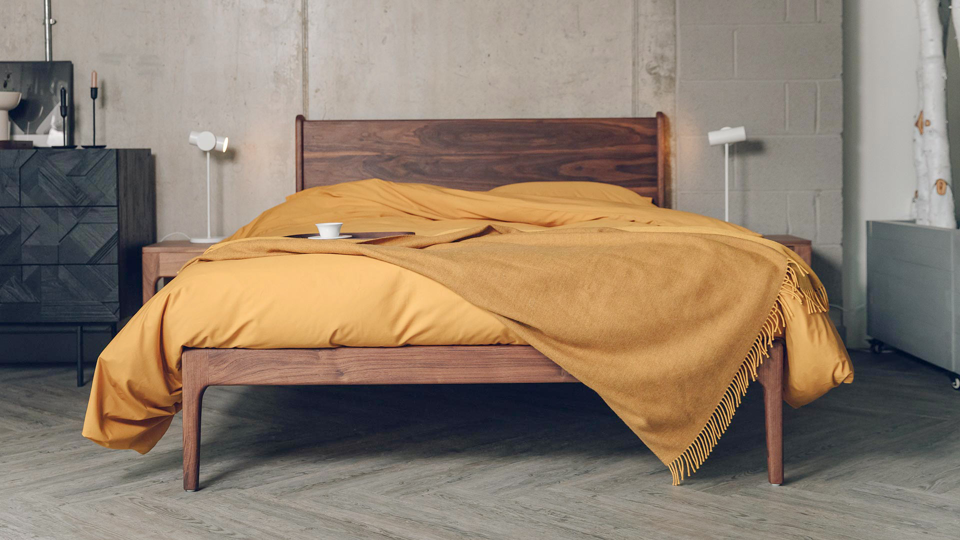camden bed in walnut with ochre coloured cotton bedding and matching wool throw.