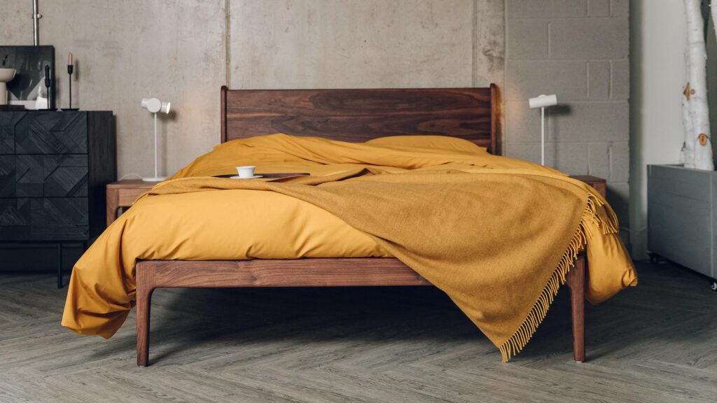camden bed in walnut with oiled finish and ochre bedding.