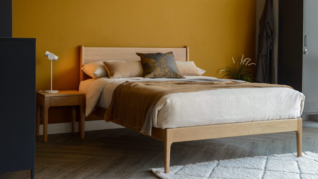 solid oak handmade camden bed with neutral bedding and grey lockers.