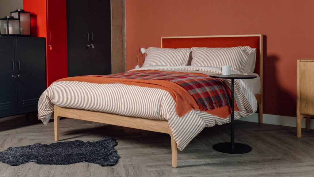 carlisle oak bed striped bedding adjustable side table and charcoal sheepskin