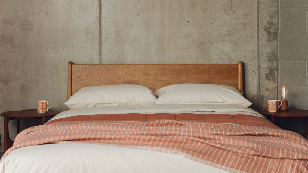 Mid century style Carnaby bed in Cherry wood shown with cream and terracotta bedding