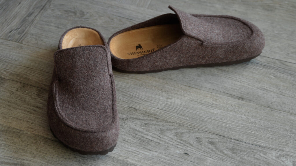 backless wool slippers in warm brown. Shepherd logo visible on sole.