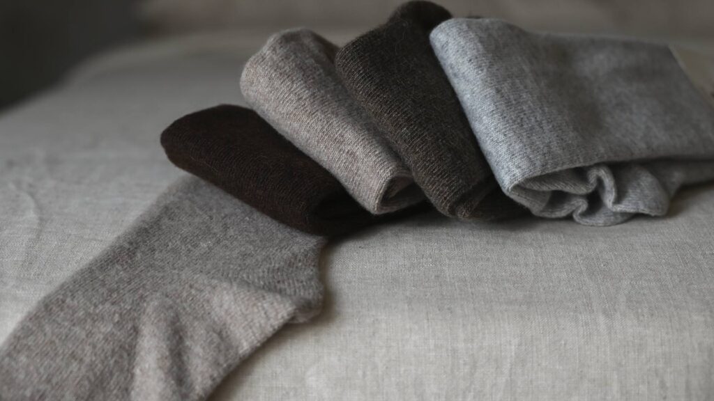 Dark brown, oatmeal, mid brown and grey socks folded.