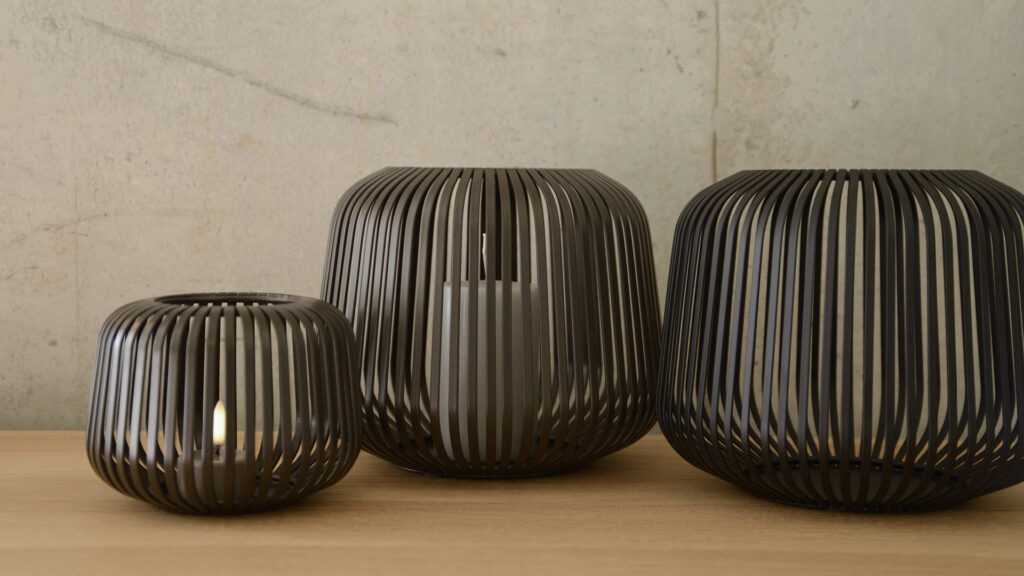 three metal lanterns. Large and small in bronze and a large in black.