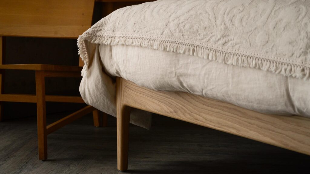 ecru linen bedding and embroidered throw carlisle bed leg in oak