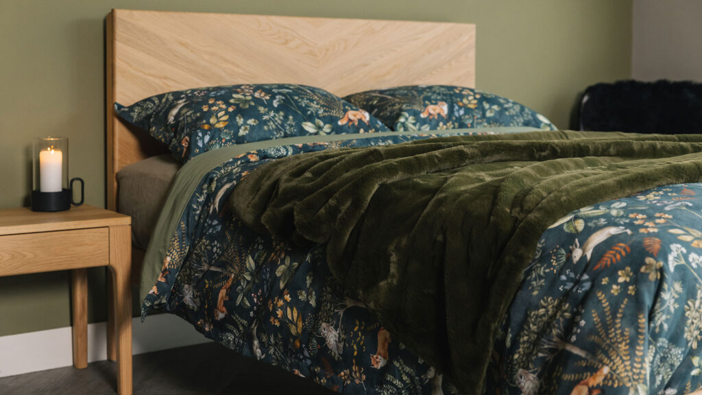 Dark green duvet cover and pillowcase set with a nature print of foxes, plants, and owls