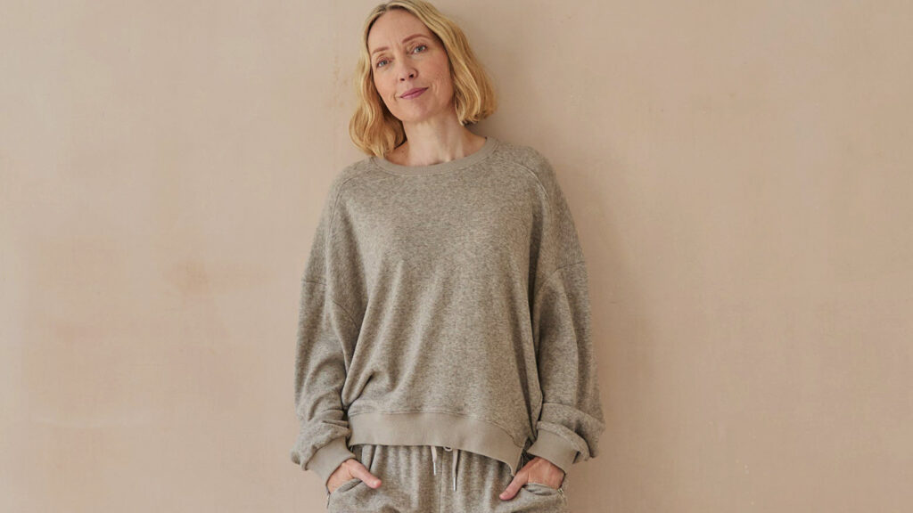 Model wearing greige sweater in a short length.