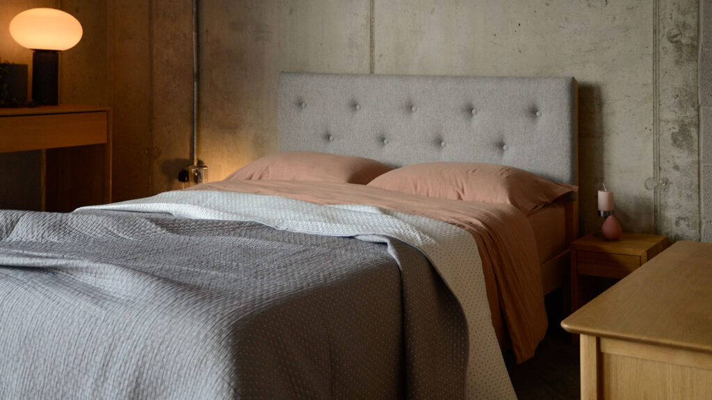 grey and white reversible quilt with warm pink bedding on arran bed