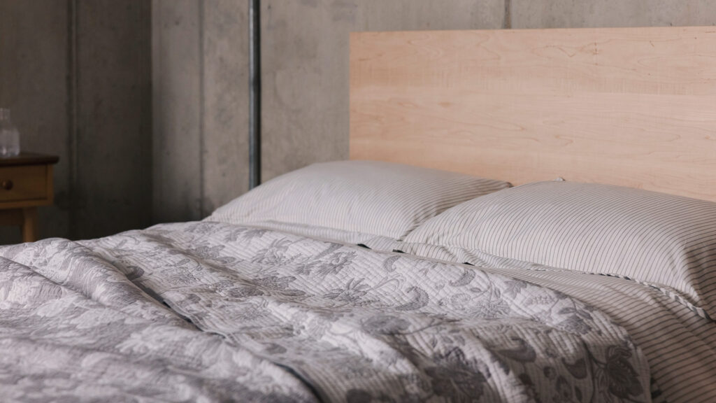 grey striped bedding and floral bedspread