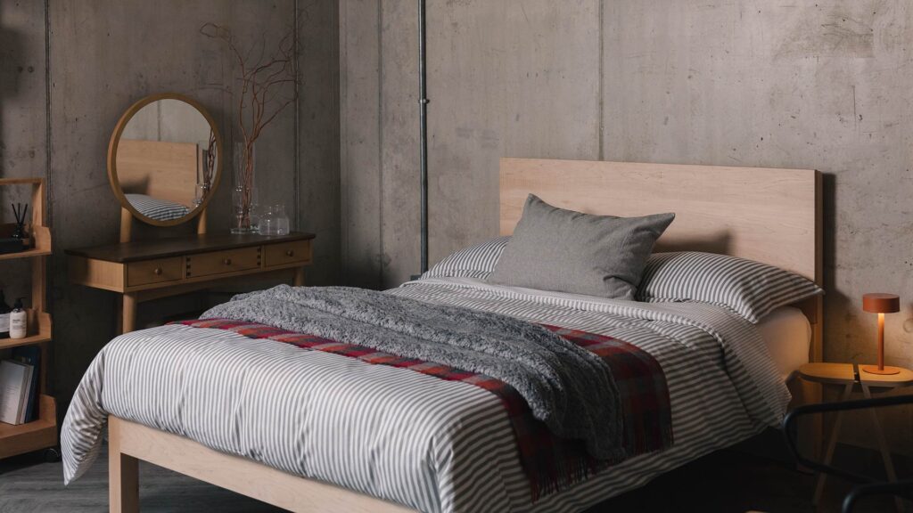 grey striped bedding with red check throw and maple bamford bed