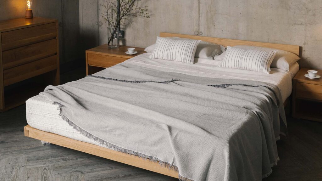 low oak bed with silver grey bedspread