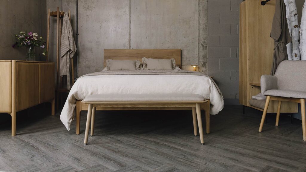 Bedroom scene with oak furniture and stone bedding.