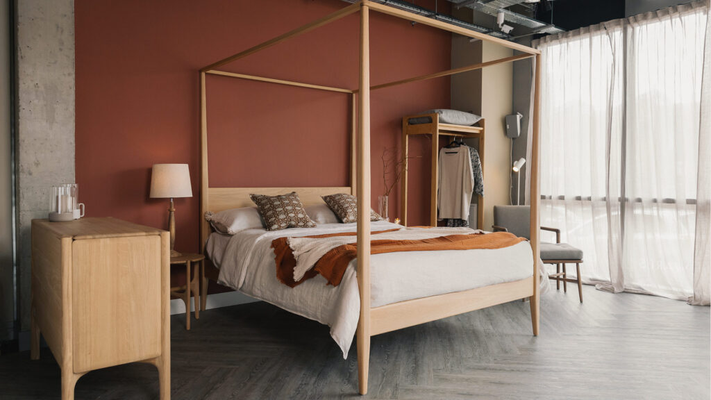 oak Canterbury bed with linen bedding and muslin throws