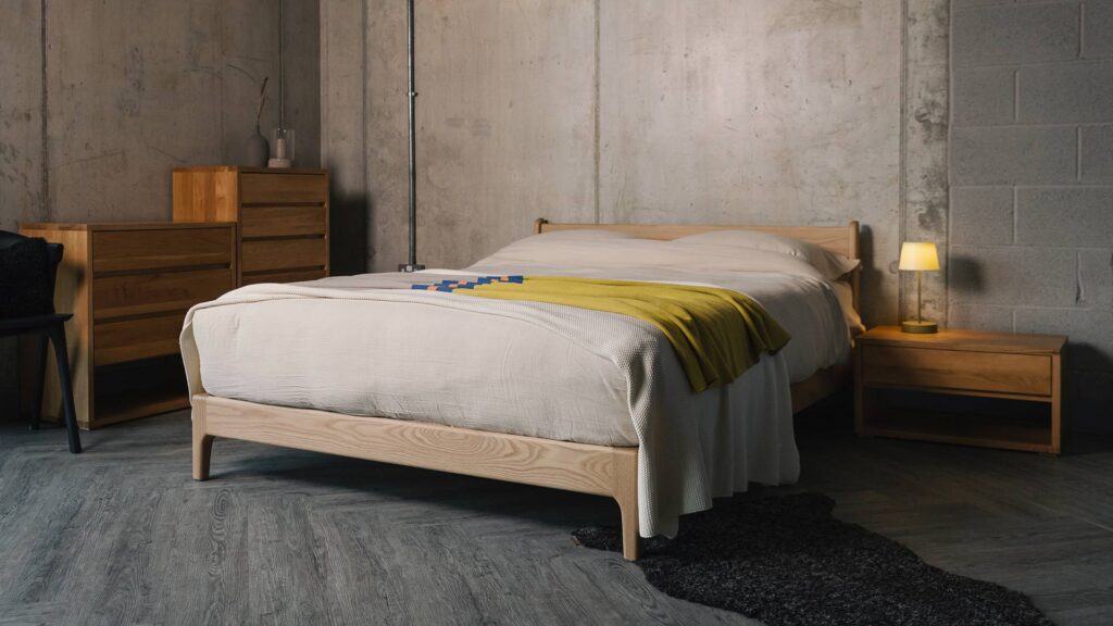 oak Pimlico bed with colourful throw and curly sheepskin