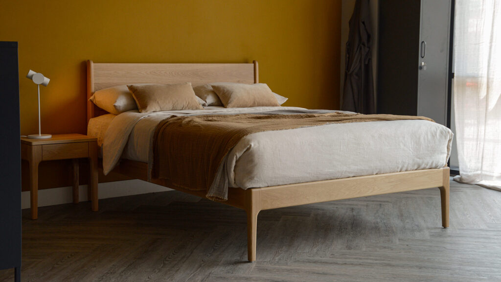 Our mid century style Camden bed made from solid oak wood with matching bedside table and ecru linen bedding