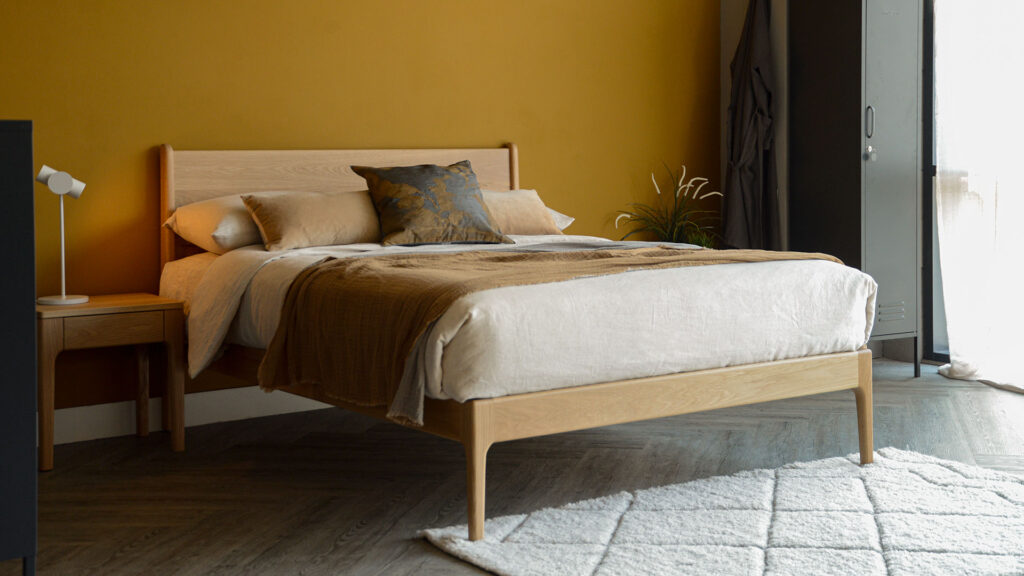 Our mid century style Camden bed made from solid oak wood with matching bedside table and ecru linen bedding