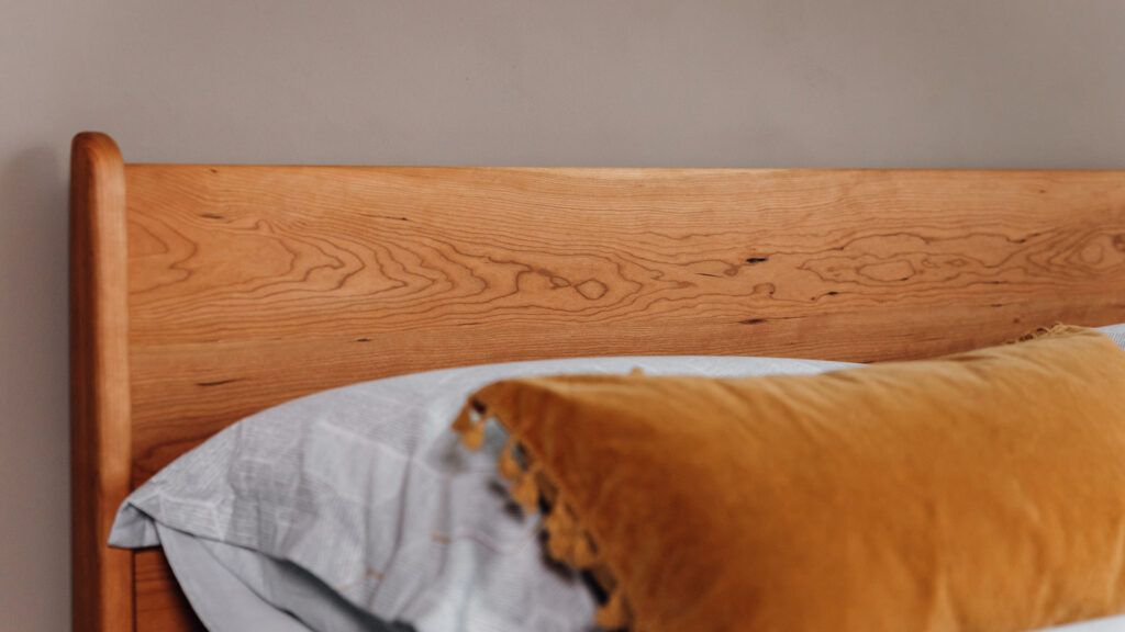 oiled cherry Camden bed headboard, curved leg detail.