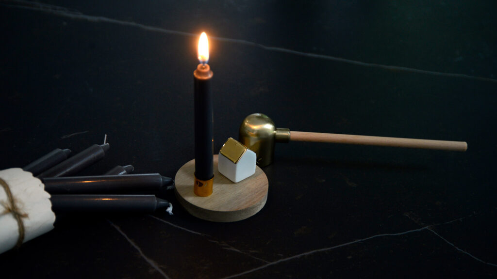 mini candle holder with a wooden base and porcelain house with gold roof