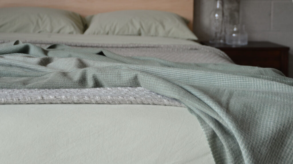 sage green bedding with gradient throw