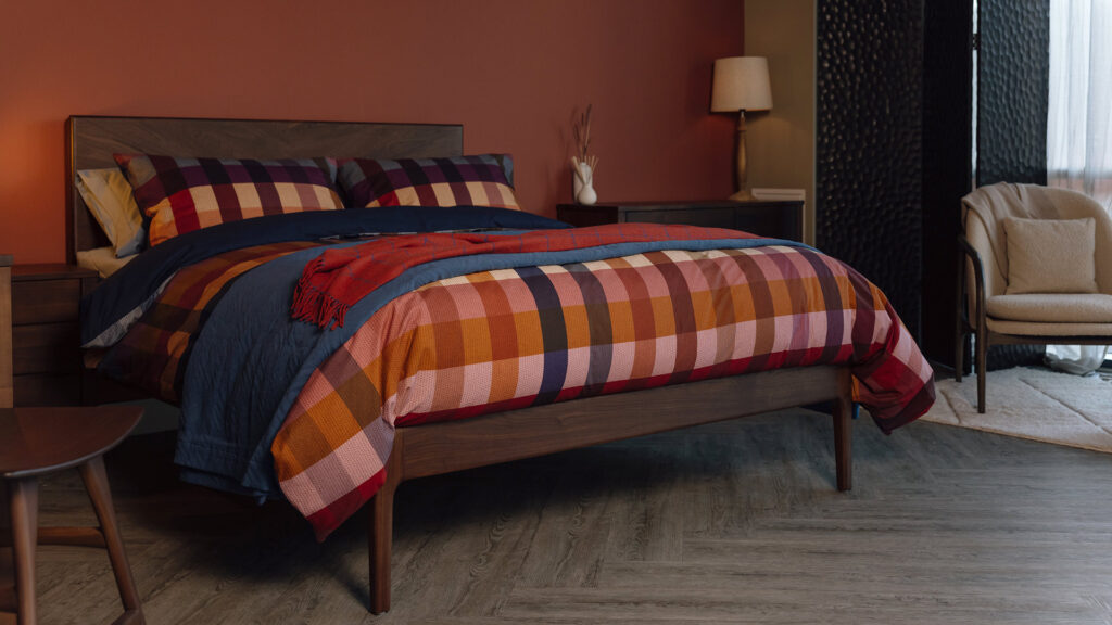 smoked walnut bed dressed in bold check pattern bedding.