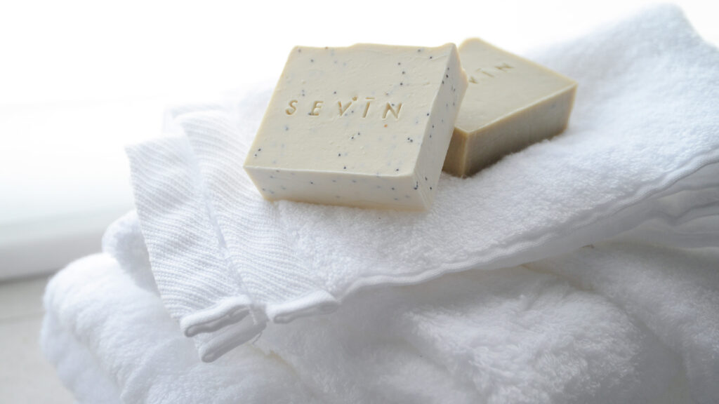 Sevin luxury natural soaps shown with fluffy white towels