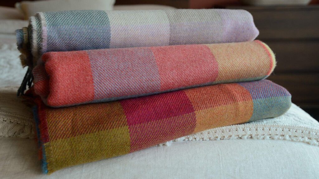 stack of multicolour check lambswool throws   3 colourways