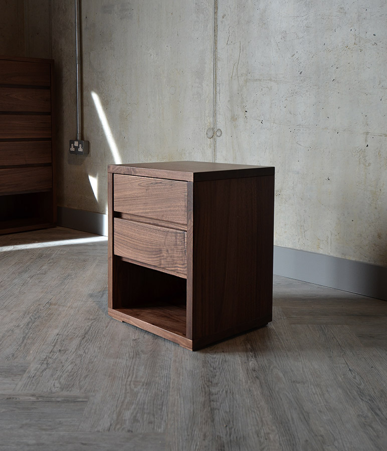 A side view of the Black Lotus Walnut 2 Drawer Cube Bedside Table.
