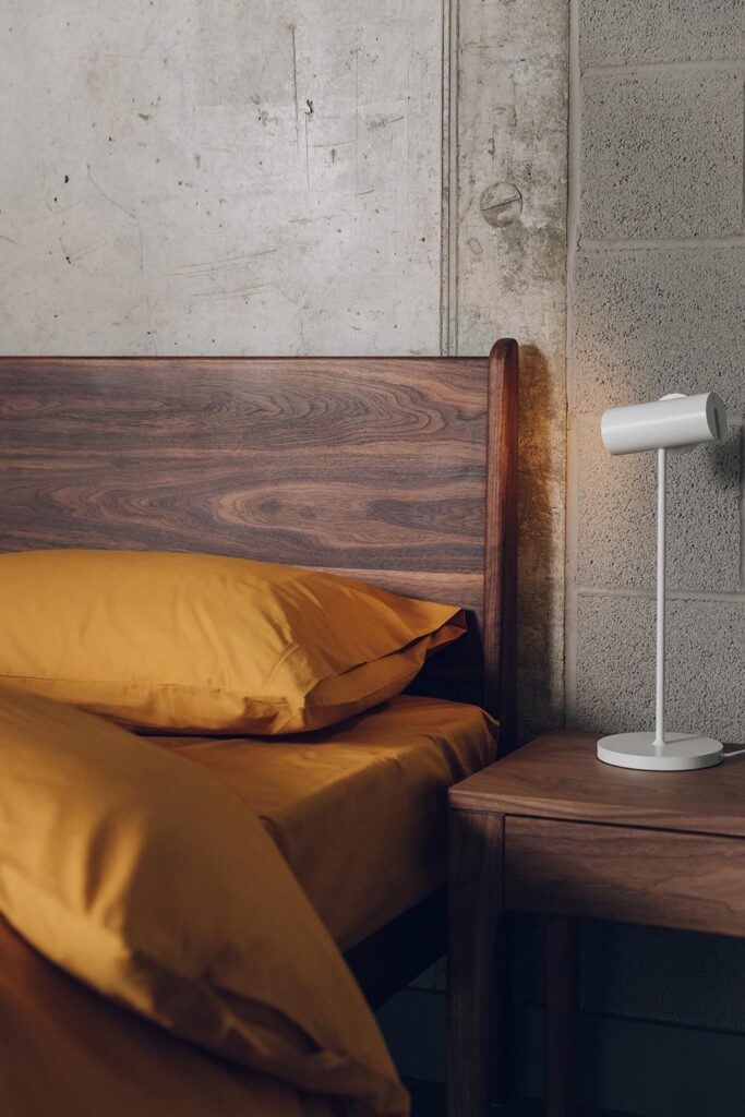 walnut bed Camden headboard detail with ochre bedding portrait.