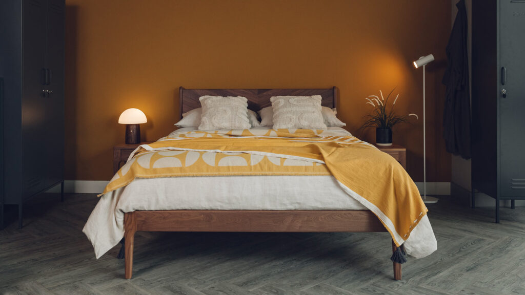 walnut hoxton bed with ochre and ecru bedding and mushroom lamp